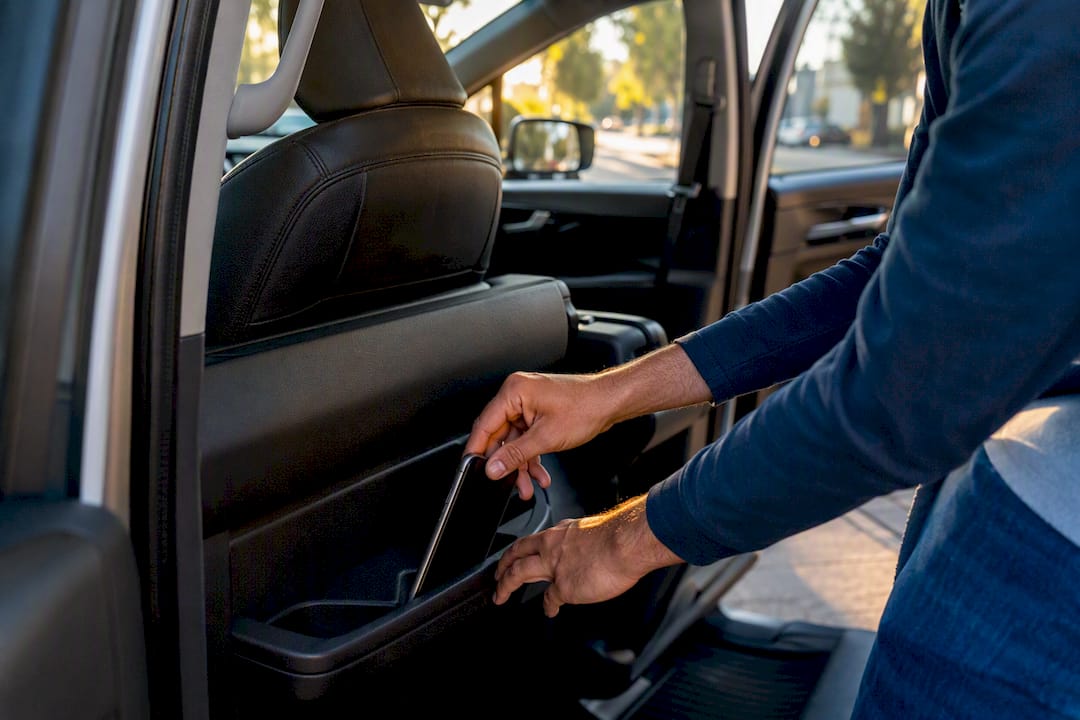 Hands placing smartphone into car cup holder